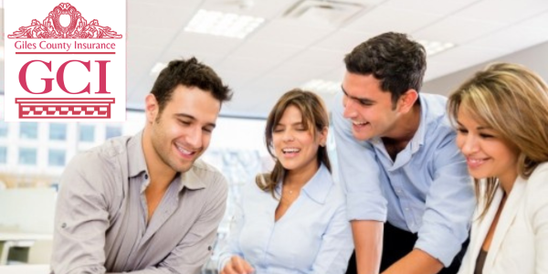 People laughing around a work project on a desk